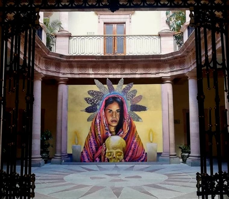 mural colorido de uma mulher indígena segurando uma caveira em um museu chamado Casa del Conde Rul |  o que fazer em Guanajuato, México