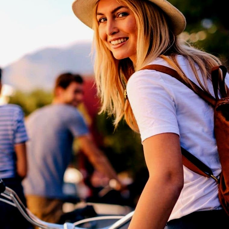 Mulher feliz em um passeio de bicicleta com amigos do sexo masculino |  Supere a ansiedade de viajar sozinho