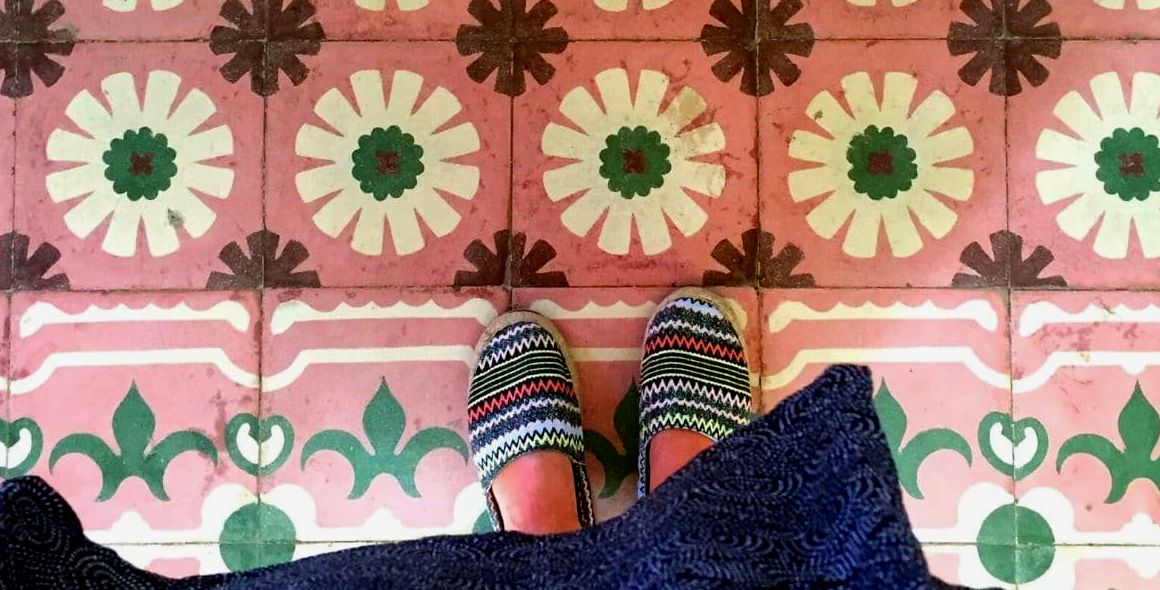 Mulher usando sapatos Merida Mexico Yucatan em pé sobre azulejos florais coloridos, rosa e verdes