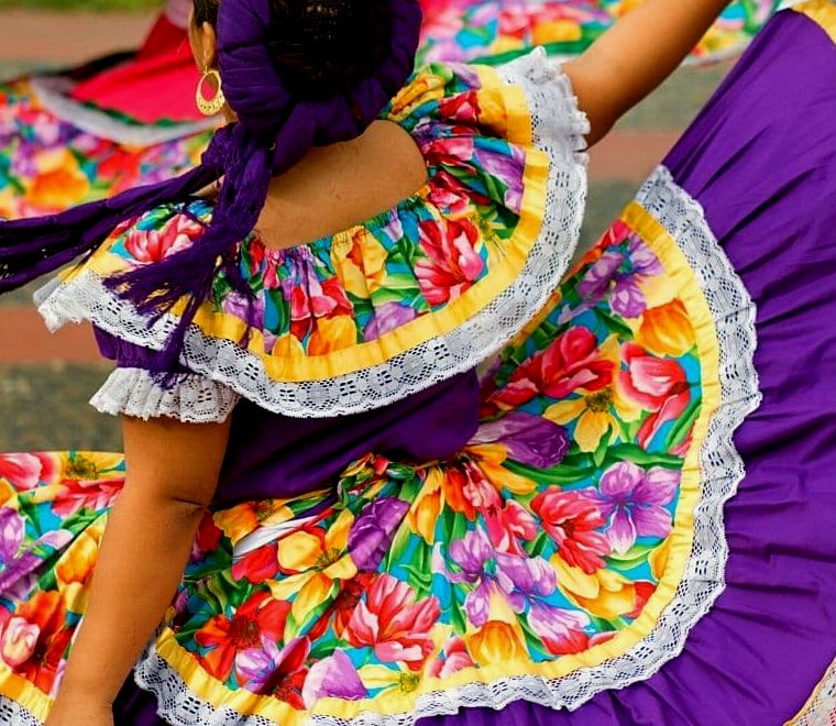 Mulher com vestido tradicional mexicano fazendo uma dança