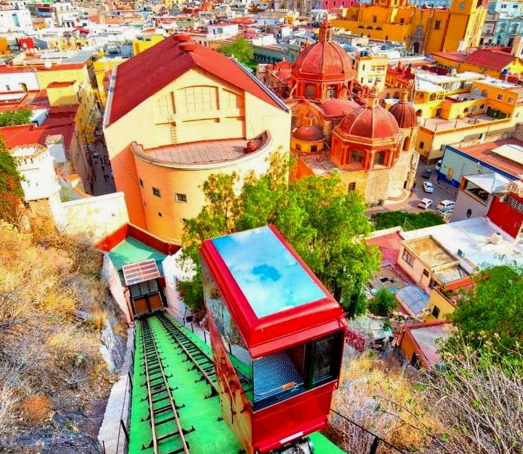 Teleférico subindo uma montanha em uma cidade colorida