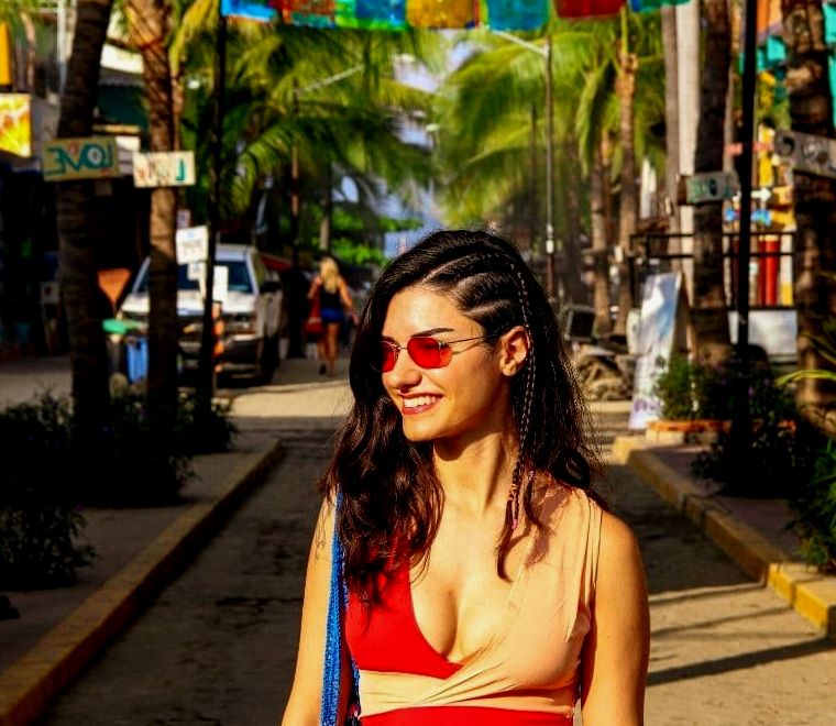 mulher sorrindo em uma rua colorida em Sayulita, uma das melhores cidades litorâneas mexicanas