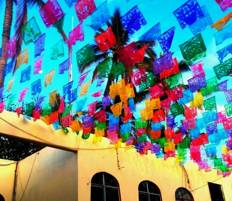 Bandeiras coloridas de arte popular mexicana (papel picado) em uma rua em Todos Santos pueblo magico (cidade mágica), um ótimo lugar para viagens Solo México em Baja California, México,
