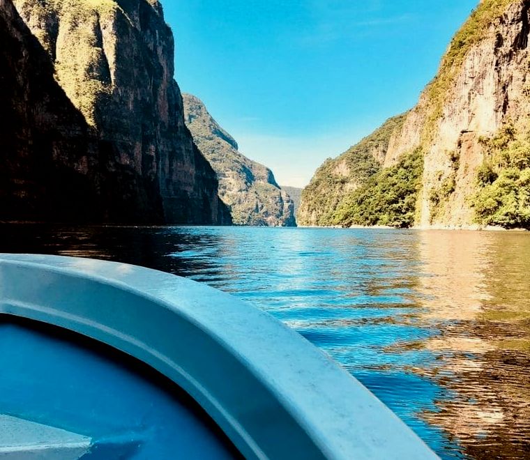 barco azul menor se aproximando do grande Sumidero Canyon, um dos lugares mais exclusivos para se visitar no México