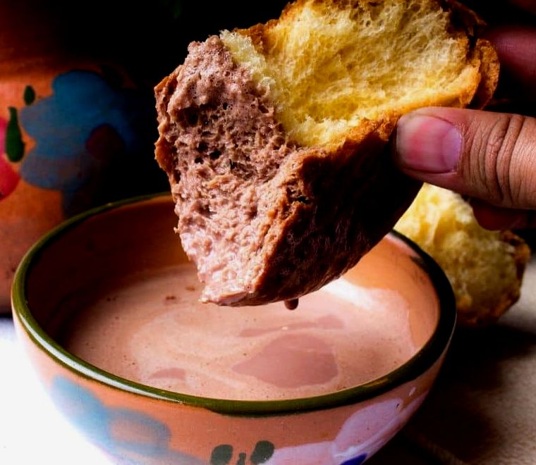 mergulhando um pedaço de pão em uma xícara de chocolate quente