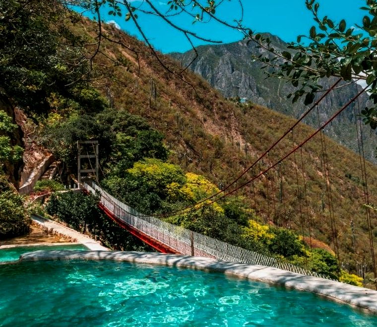 piscinas de água azul com uma ponte ao fundo - Visite Las Grutas Tolantongo