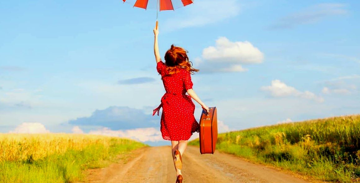 Mulher com guarda-chuva pula de alegria