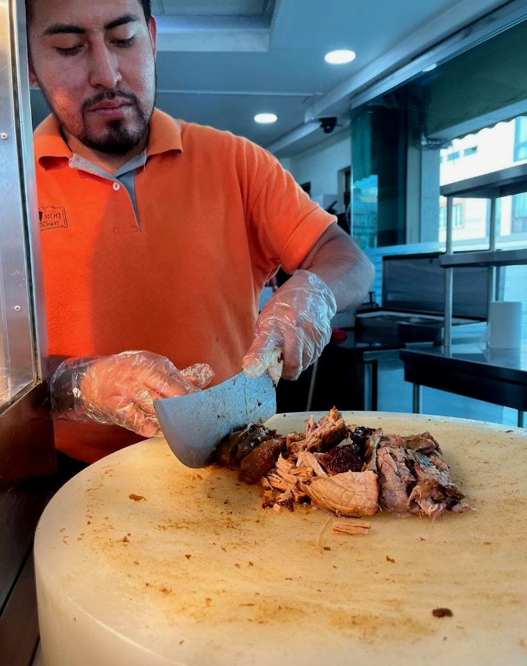 homem esculpindo carnitas para tacos no México