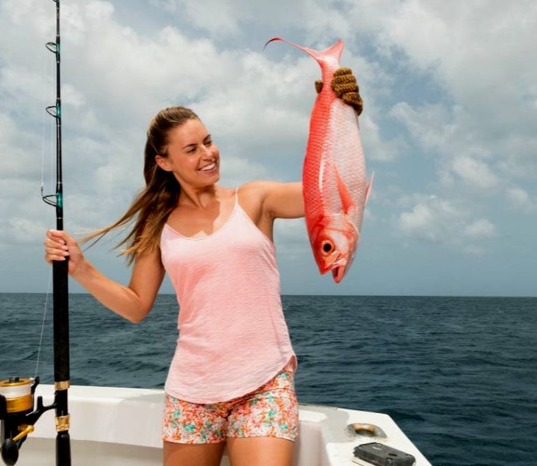mulher exibindo sua captura durante a pesca em Puerto Vallarta