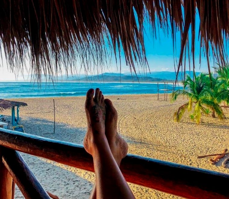 pés de uma mulher em uma grade em uma cabana tropical à beira-mar em chacahua, oaxaca, méxico |  Melhores praias de Oaxaca