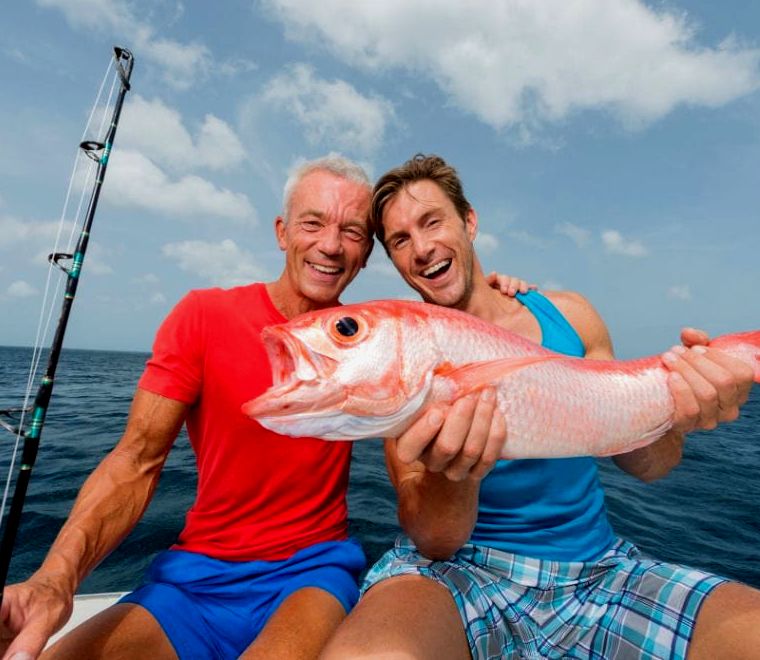 dois convidados exibindo alegremente suas capturas - Cartas de pesca em Cabo