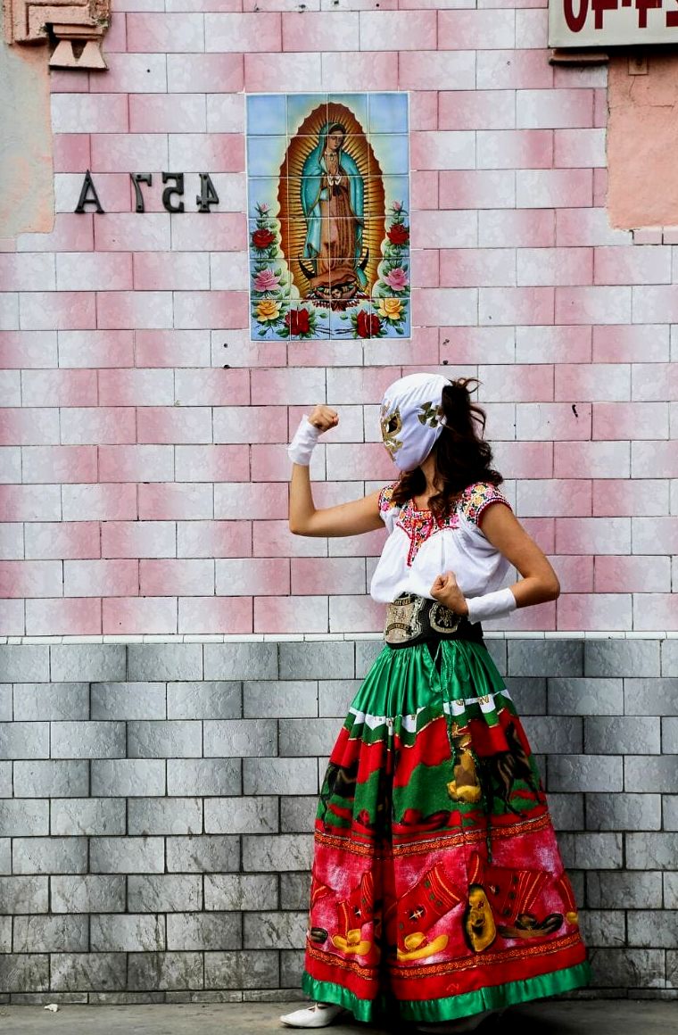 mulher com máscara de lucha libre e vestido tradicional mexicano