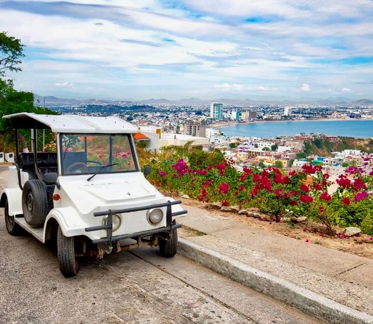 carrinho de golfe em uma estrada com vista para a costa de Mazatlán, México