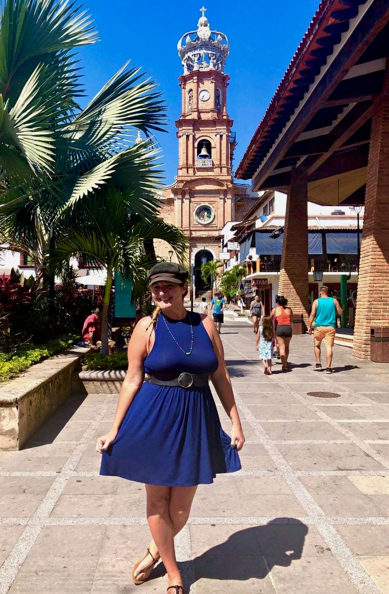 mulher de vestido azul em frente à igreja colonial em puerto vallarta méxico