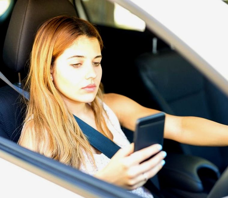 mulher falando no celular enquanto dirige