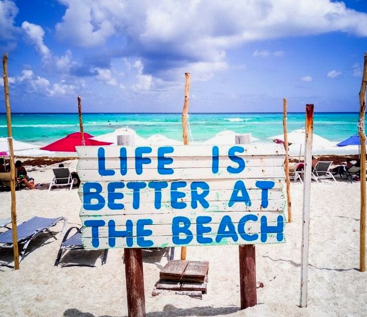 placa que diz "a vida é melhor na praia" na Riviera Maya, México
