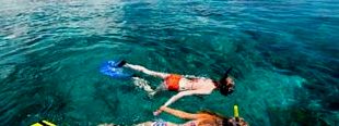 dois turistas mergulhando nas águas do México