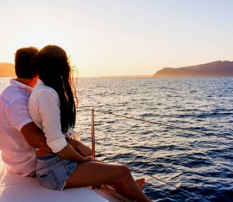 casal sentado na beira do iate assistindo o pôr do sol |  Passeios de barco em Puerto Vallarta