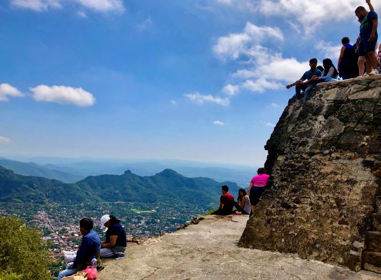 pessoas em uma pirâmide no topo de uma montanha em um dos melhores pueblos magicos do México |  pirâmide de tepoztlán tepozteco